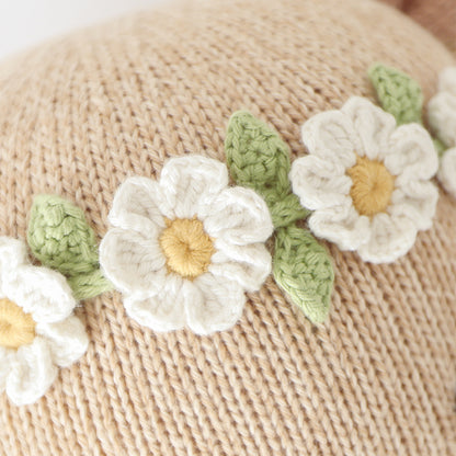 A close-up showing the hand-knit details on Olivia's daisy chain flower crown.