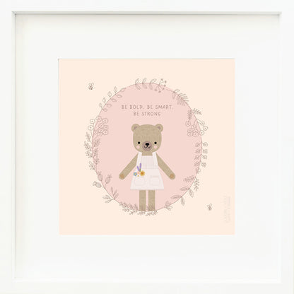 A framed print with a drawing of Goldie the honey bear and text that says “Be bold, be smart, be strong.”