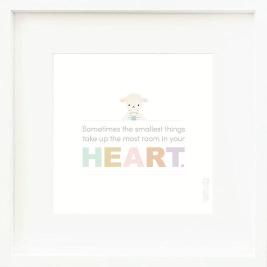 An inspirational print with a graphic of Avery the lamb on a white background with the words “Sometimes the smallest things take up the most room in your heart” in gray, with the word “heart” in rainbow block letters.