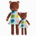 Ivy the bear in the regular and little sizes, shown from the front. Ivy has a blue dress with big green, blue, yellow and pink polka dots, and a pink bow on her head.