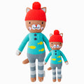 Maximus the cat in the regular and little sizes, shown from the front. Maximus is wearing a blue sweater with yellow fish on it, grey striped pants, and a red pom-pom hat.