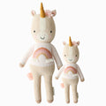 Zara the unicorn in the regular and little sizes, shown from the front. Zara is pink, and her shirt has a rainbow on it with white tassels.