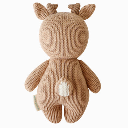 The baby fawn doll shown from the back. It has a pointed brown and white yarn tail.