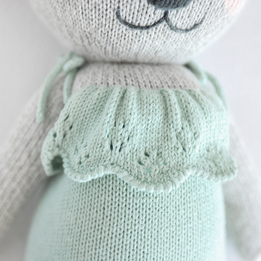 A close-up of Claire the koala, showing the hand-knit ruffled details on her romper.