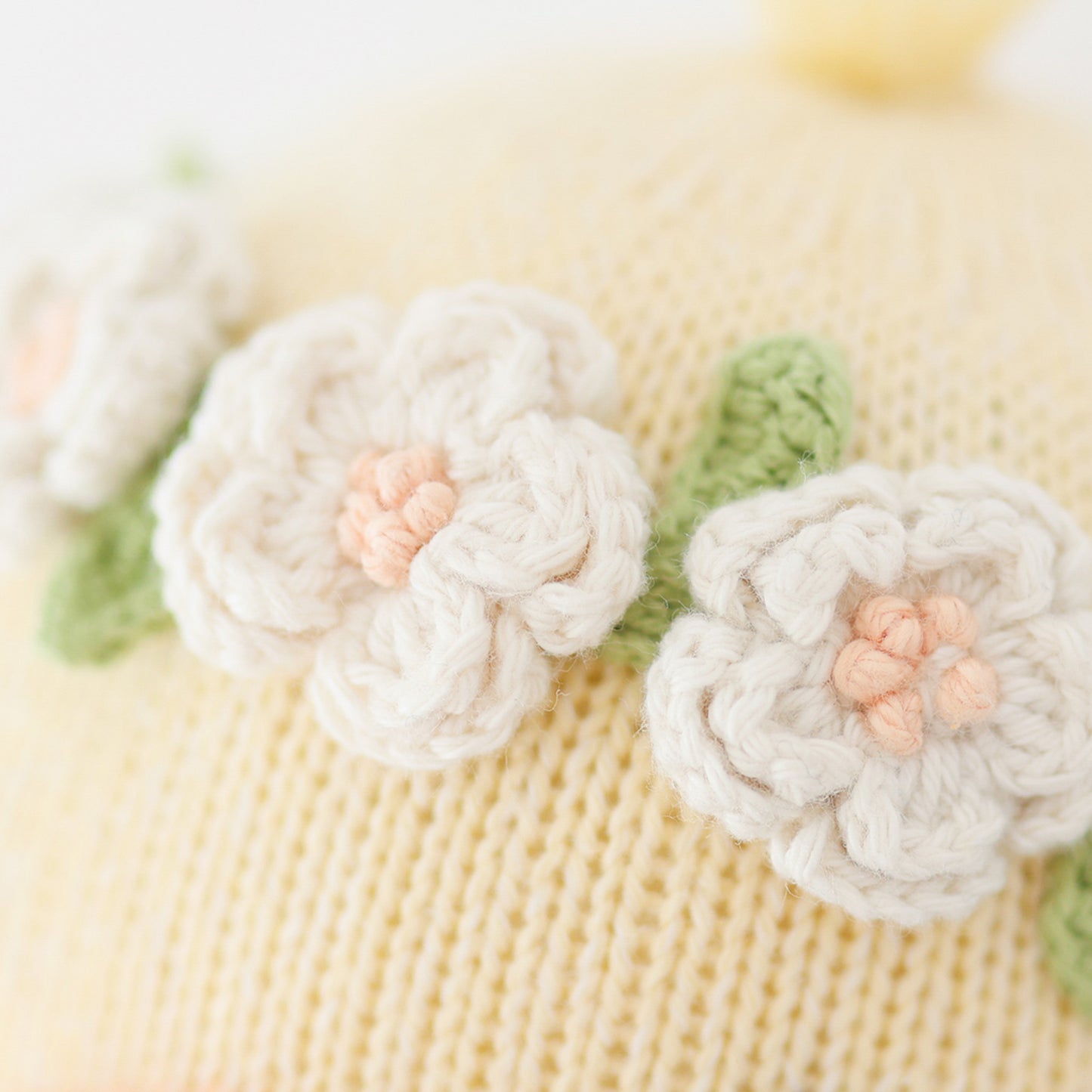 A close-up showing the hand-knit details on Flora’s flower crown.