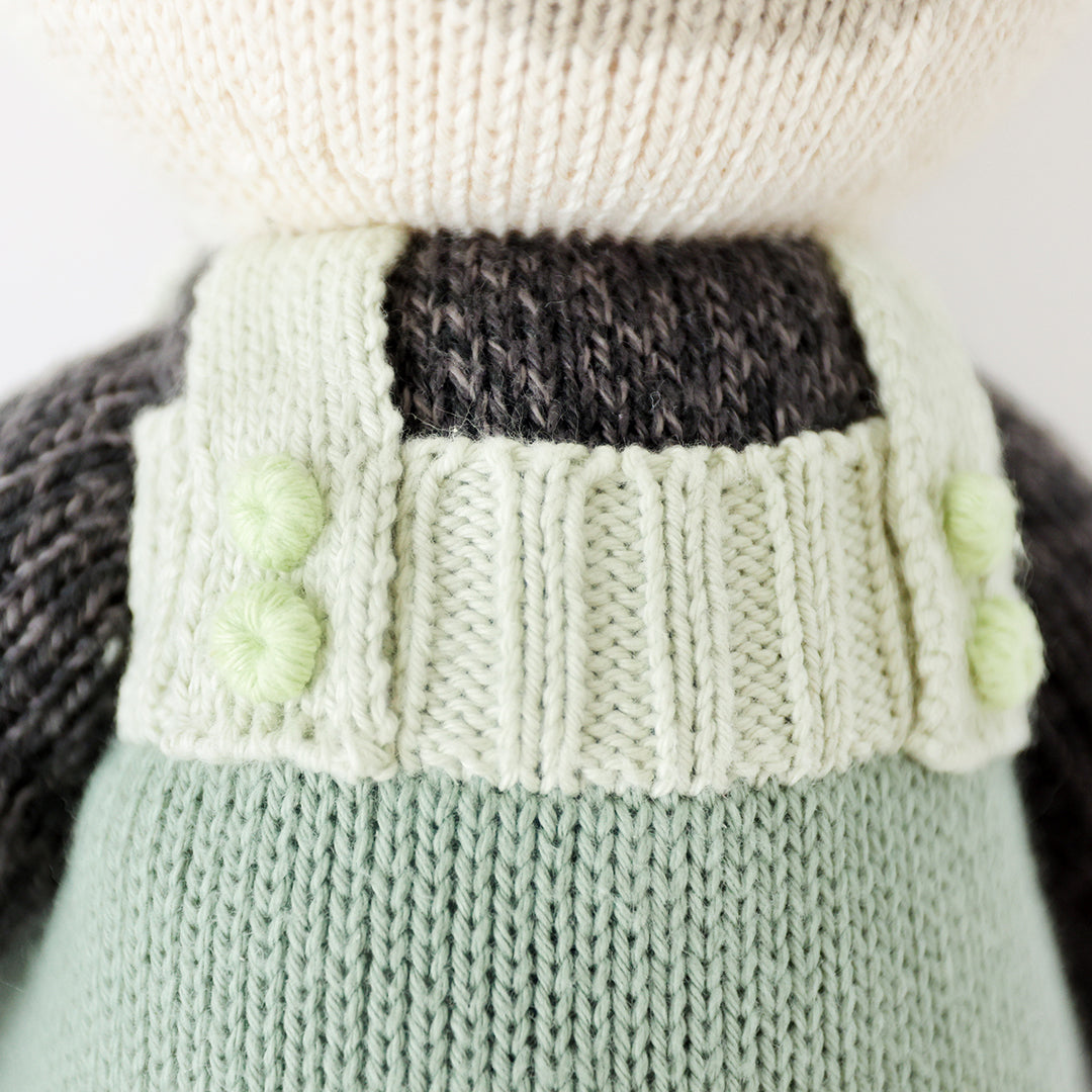 A close-up showing the hand-knit details of Paxton the panda’s knit buttons.