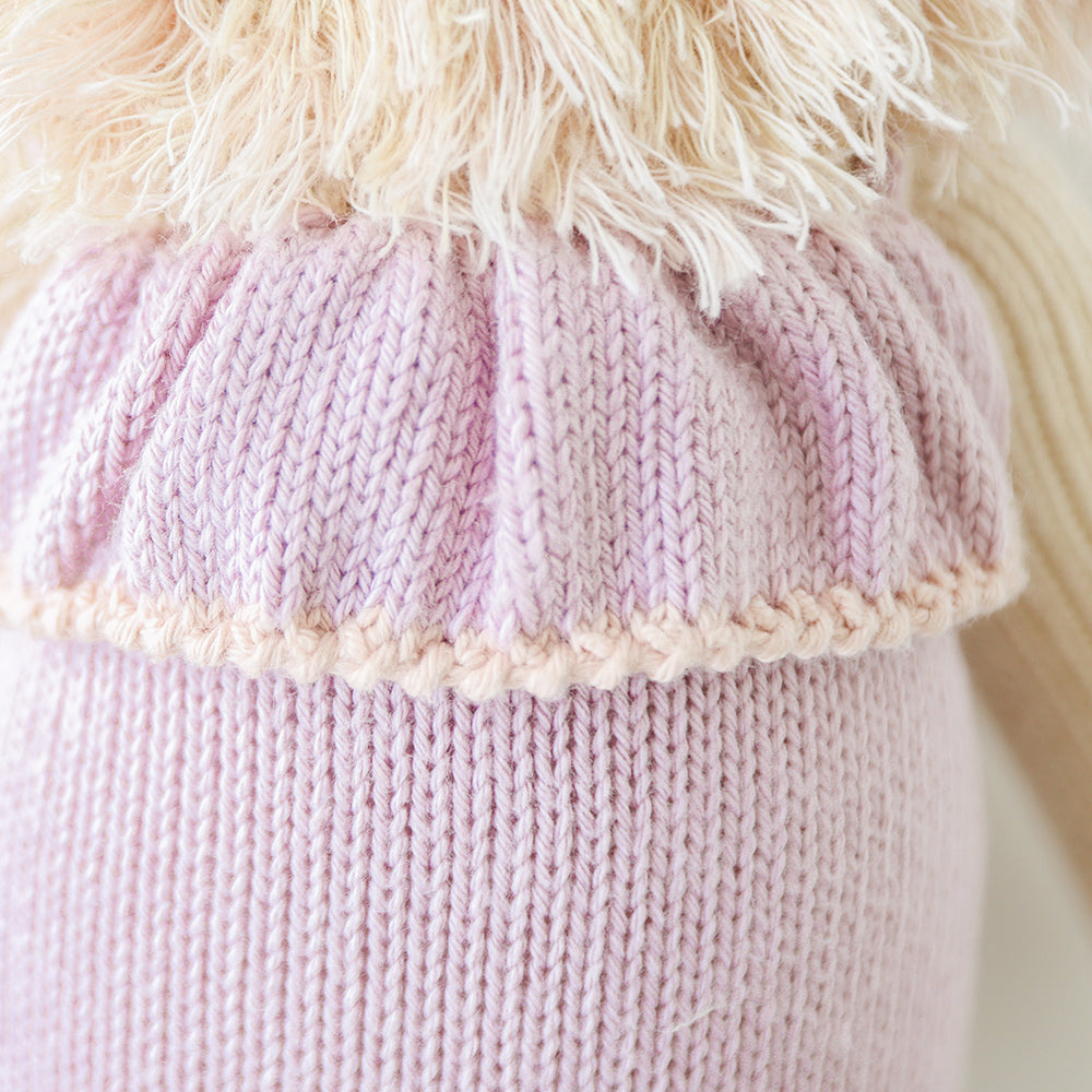 A close-up showing hand-knit details on Savannah the lion’s outfit.