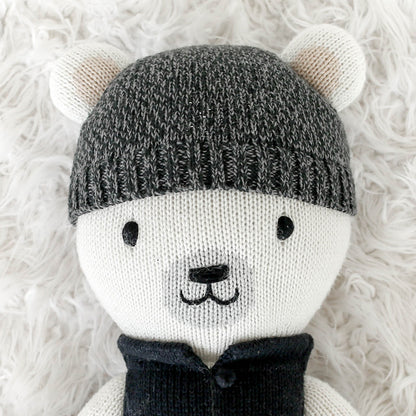 A close-up showing Hudson’s face and unique, hand-knit details like his knitted hat.