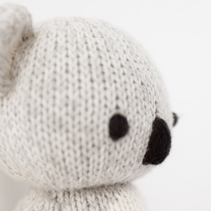 A close up showing the hand-knit details on baby koala, including one of its ears and its nose.