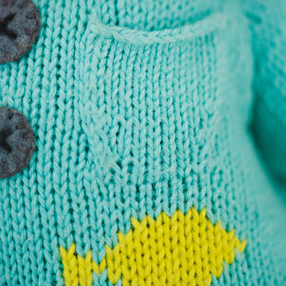 A close-up showing a hand-knit pocket on Maximus the cat’s sweater.