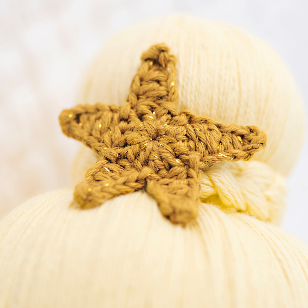 A close-up showing a hand-knitted star on top of Skye’s bun.