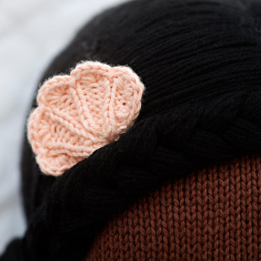 A close-up showing the hand-knitted shell in Maya’s hair.