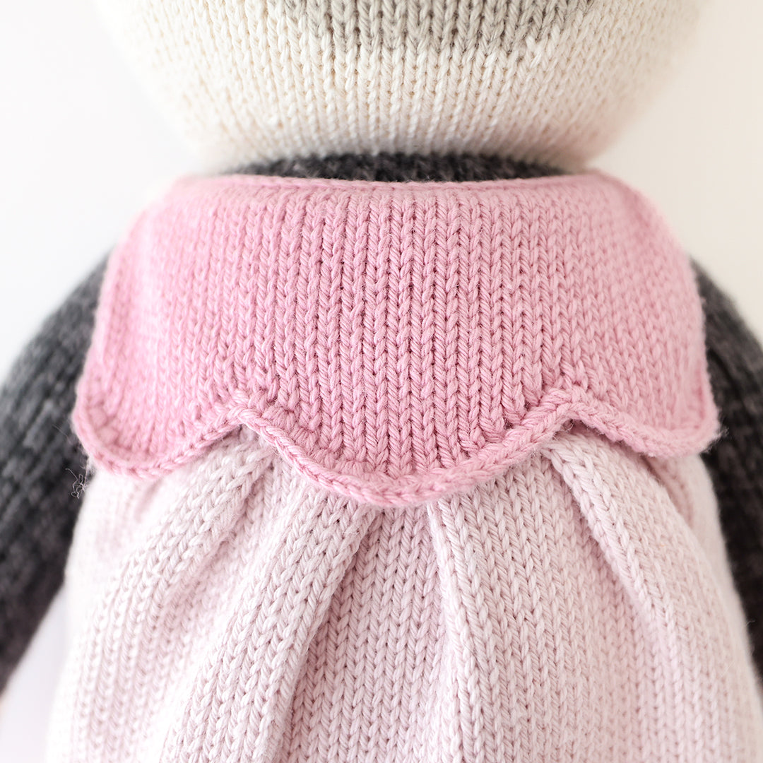 A close-up showing the hand-knit details on Polly the panda’s scalloped dress.