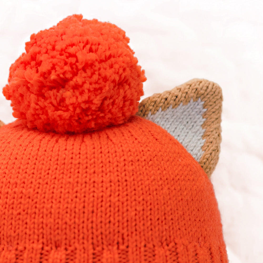 A close-up showing Maximus the cat’s pom-pom hat.