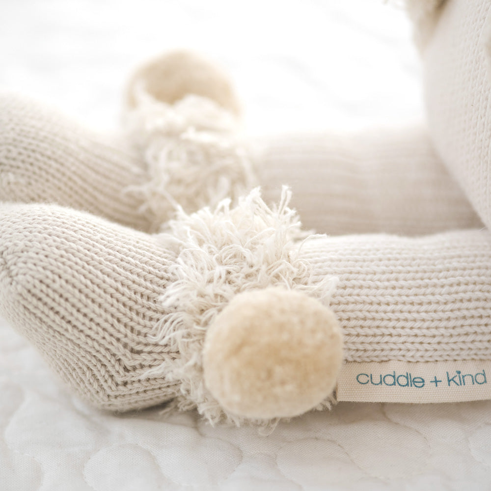 A close-up showing Stella’s boots, with fluffy yarn trim and pom-poms.