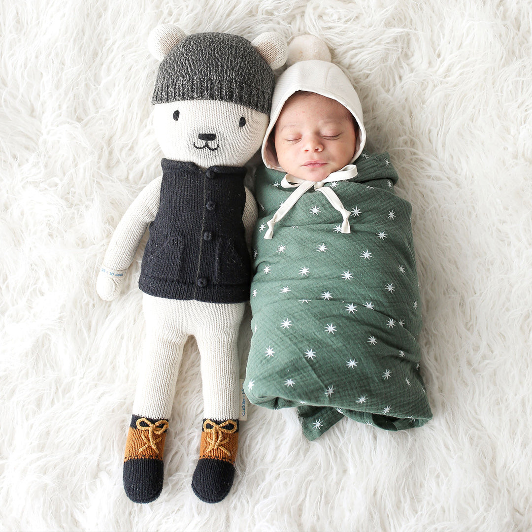 A sleeping baby snuggled up beside Hudson the polar bear in the regular size.