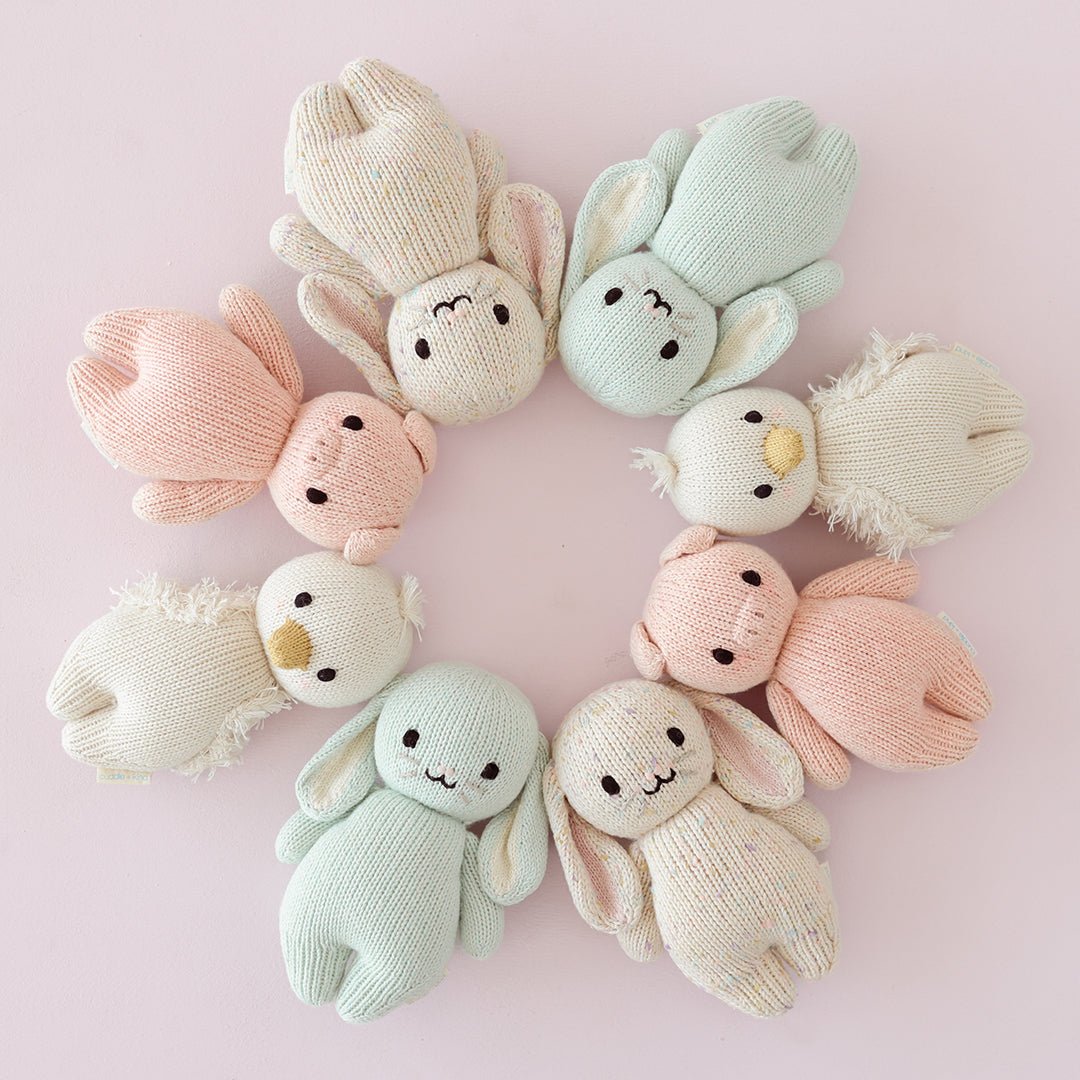 Eight baby animal stuffed dolls lying head-to-head in a circle.