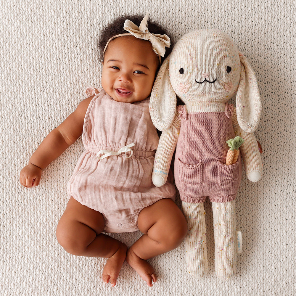 A laughing baby snuggled up beside Harper the bunny.