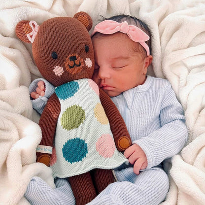 A sleeping baby with an Ivy the bear stuffed doll.