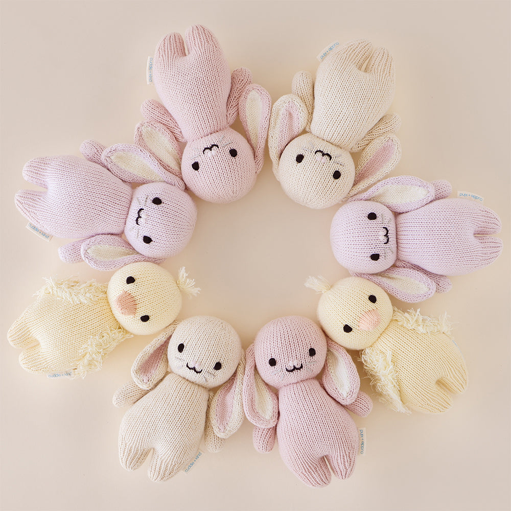 Eight baby animal stuffed dolls lying head-to-head in a circle.