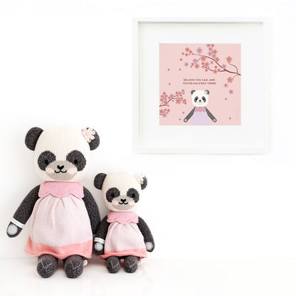 Two Polly the panda stuffed dolls sitting beside a framed print with a picture of Paxton, with text that says "Believe you can, and you’re halfway there."