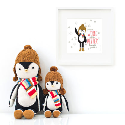 Two Everest the penguin stuffed animals sitting beside a framed print with a picture of Everest that says “Leave the world a little better than you found it.”