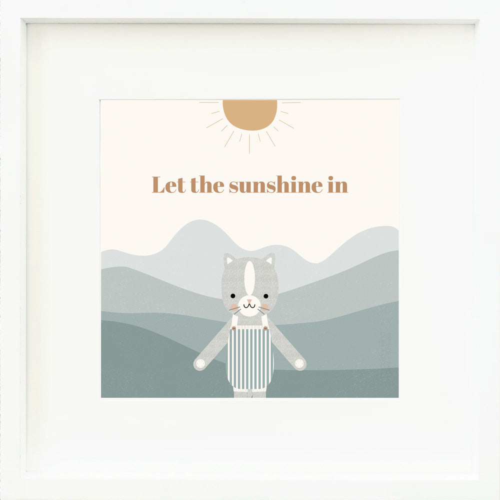 A framed print with a drawing of Dylan the kitten and text that says “Let the sunshine in.”