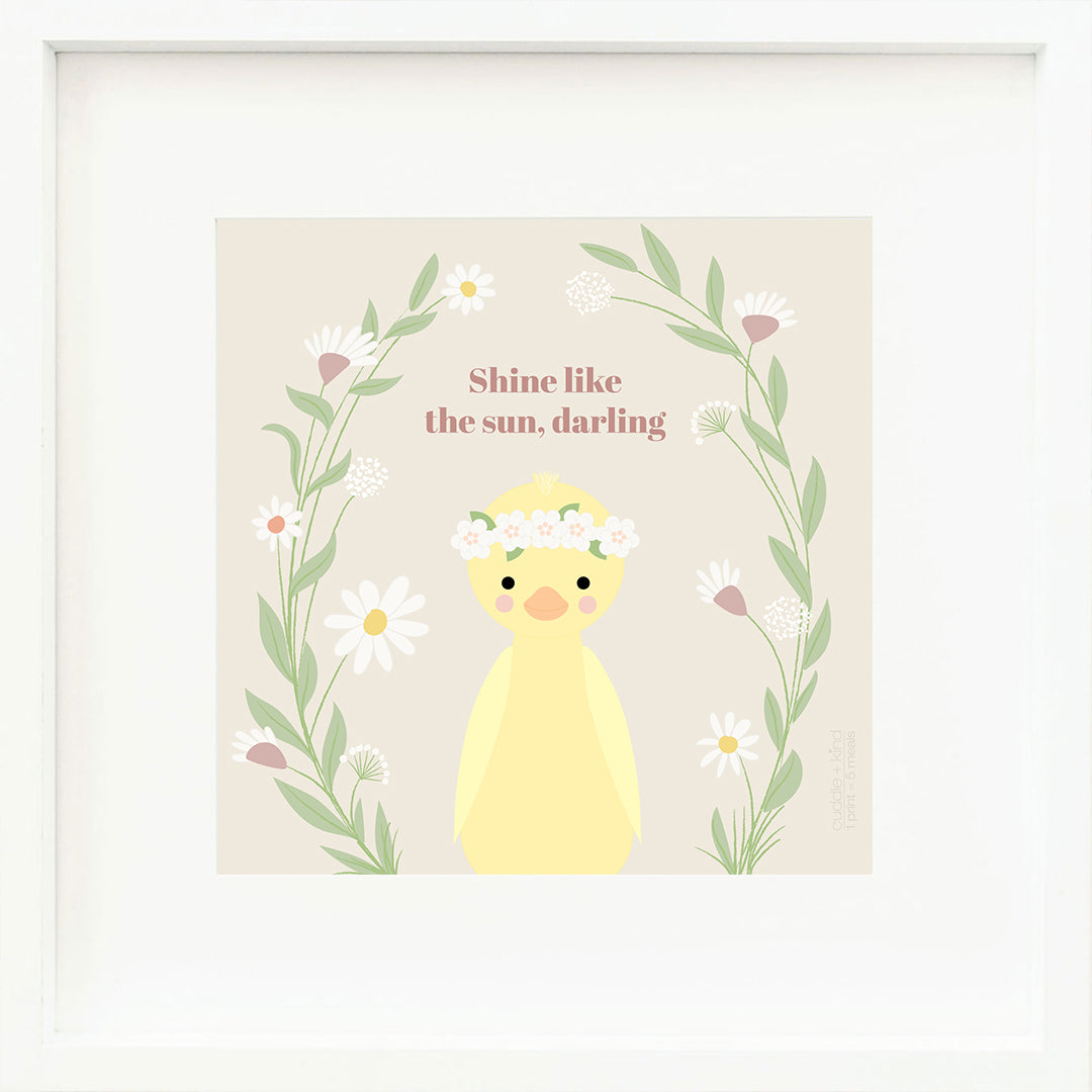 A framed print with a drawing of Flora, with text that says “Shine like the sun, darling.”