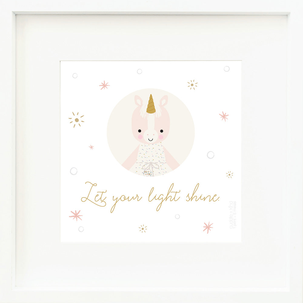 An inspirational print with a graphic of Ella the unicorn on a white background with star accents and the words “Let your light shine” in golden yellow.