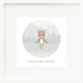 An inspirational print with a graphic of Elliot the fawn standing in a green forest. Below the drawing on a white background are the words “Adventure awaits” in gray.