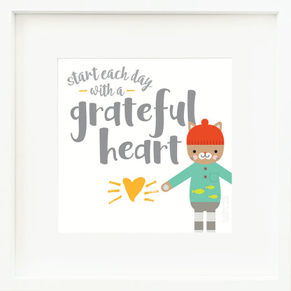 A framed print with a drawing of Maximus the cat and text that says “Start each day with a grateful heart.”