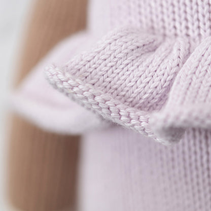 A close-up showing hand-knit details on the ruffle of Violet’s romper.