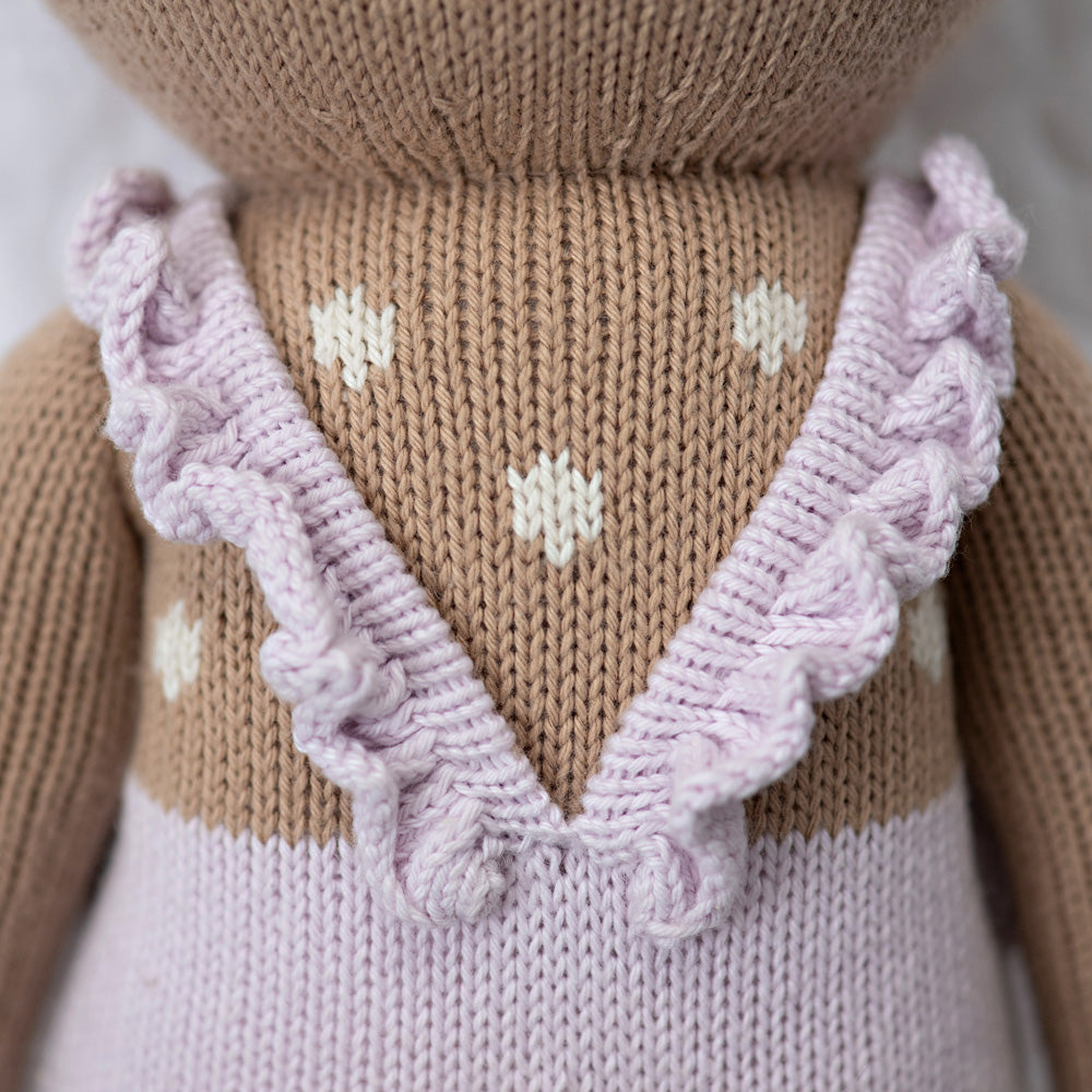 A close-up showing ruffled, hand-knit straps on the back of Violet’s romper.