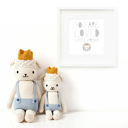 Two Sebastian the lamb stuffed animals sitting beside a framed print with a picture of Sebastian that says “You are loved little prince.”