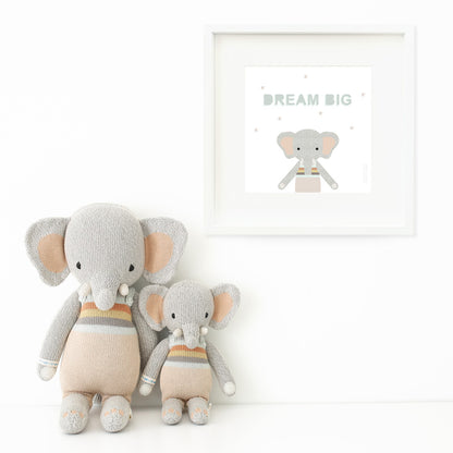 Two Evan the elephant stuffed animals sitting beside a framed print with a picture of Evan that says “Dream big.”