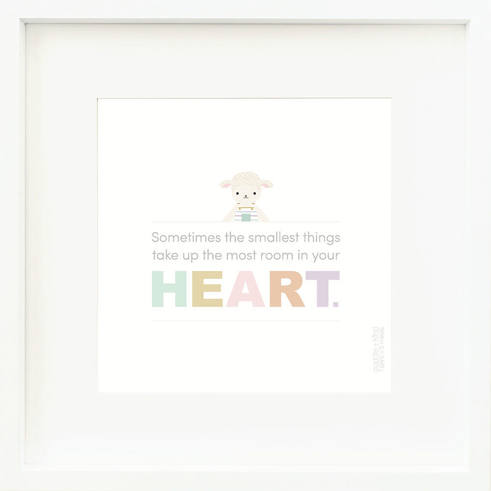 An inspirational print with a graphic of Avery the lamb on a white background with the words “Sometimes the smallest things take up the most room in your heart” in gray, with the word “heart” in rainbow block letters.