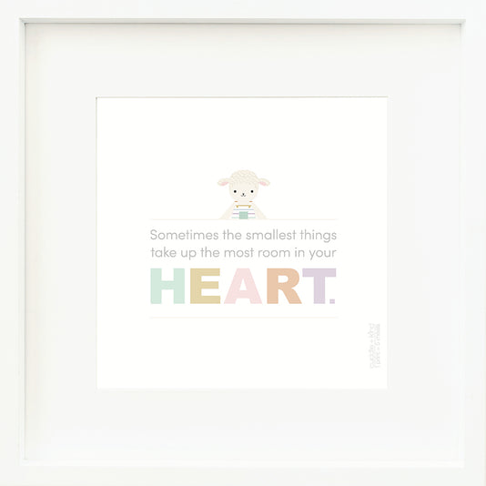 An inspirational print with a graphic of Avery the lamb on a white background with the words “Sometimes the smallest things take up the most room in your heart” in gray, with the word “heart” in rainbow block letters.