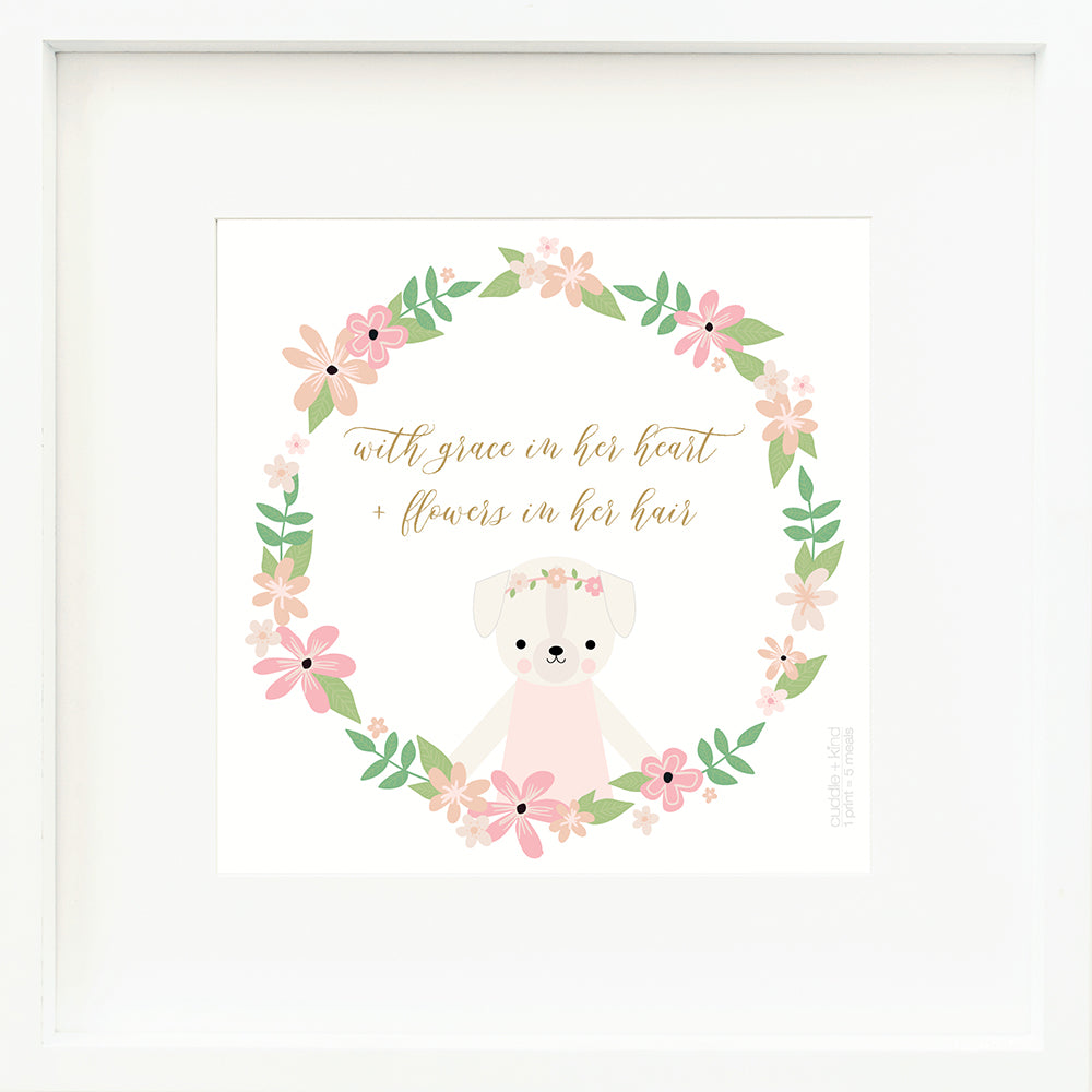 An inspirational print with a graphic of Charlotte the dog inside a ring of flowers on a white background with the words “With grace in her heart + flowers in her hair” in golden yellow.