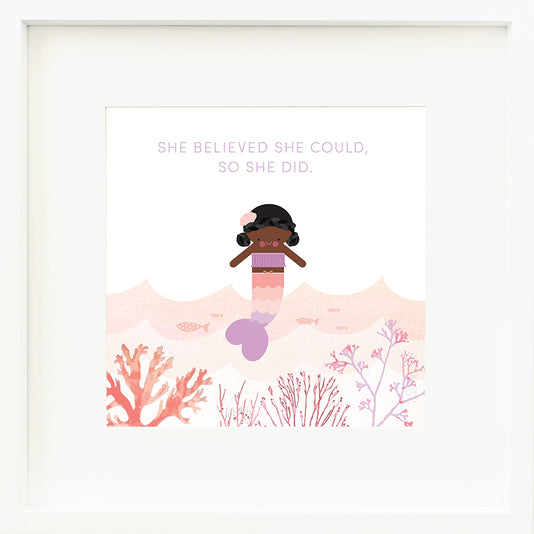 An inspirational print with a graphic of Maya the mermaid, pink water, coral reefs and fish with the words “She believed she could, so she did” in purple.