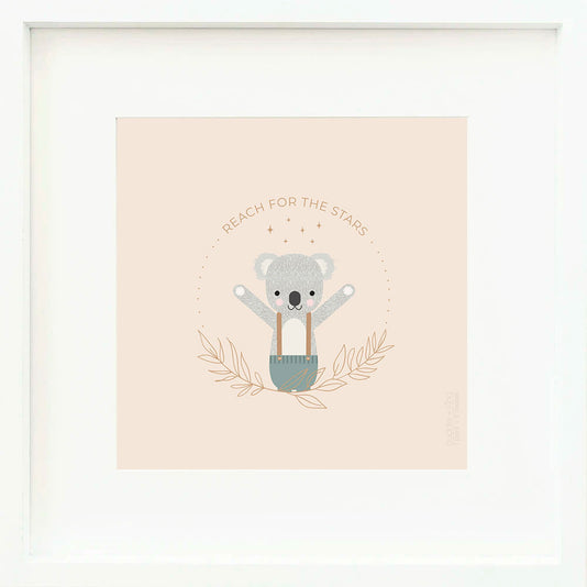 An inspirational print with a graphic of Quinn the koala with his arms in the air and the words “Reach for the stars” in brown. The background is blush-colored with drawings of leaves and stars.