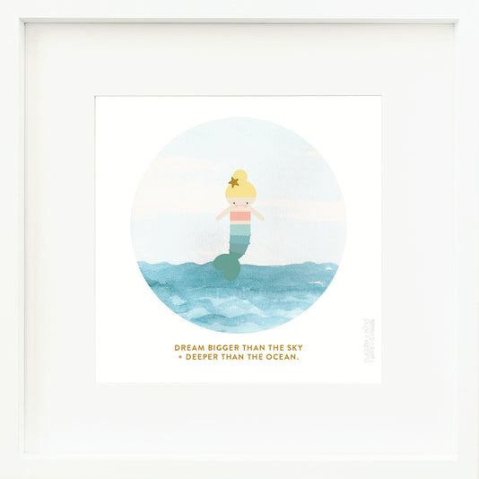 An inspirational print with a graphic of Skye the mermaid with an ocean and sky and the words “Dream bigger than the sky + deeper than the ocean” in dark yellow.