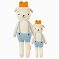 Sebastian the lamb in the regular and little sizes, shown from the front. Sebastian is wearing blue shorts and suspenders, and has a golden-yellow crown.