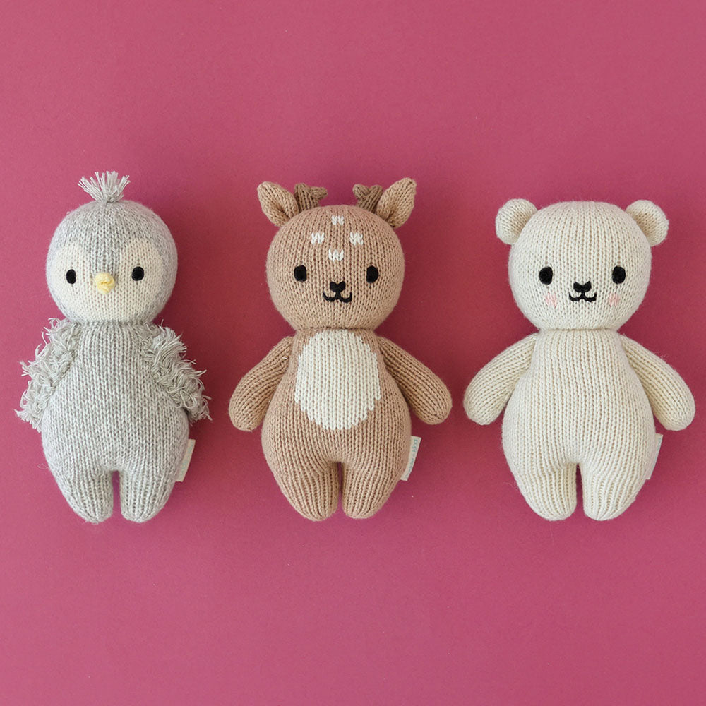 A group of three baby animal stuffed dolls: baby fawn, baby penguin and baby polar bear.