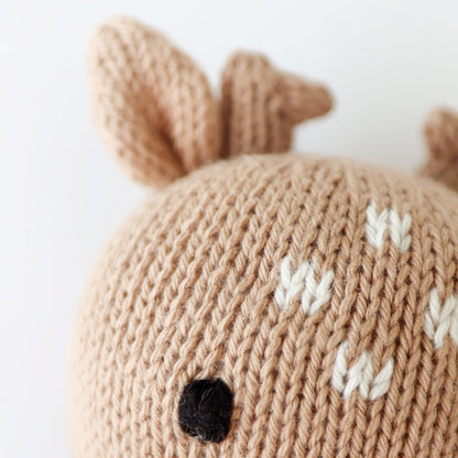 A close up showing the hand-knit details on baby fawn, including its little white dots and hand-knit ears and antlers.