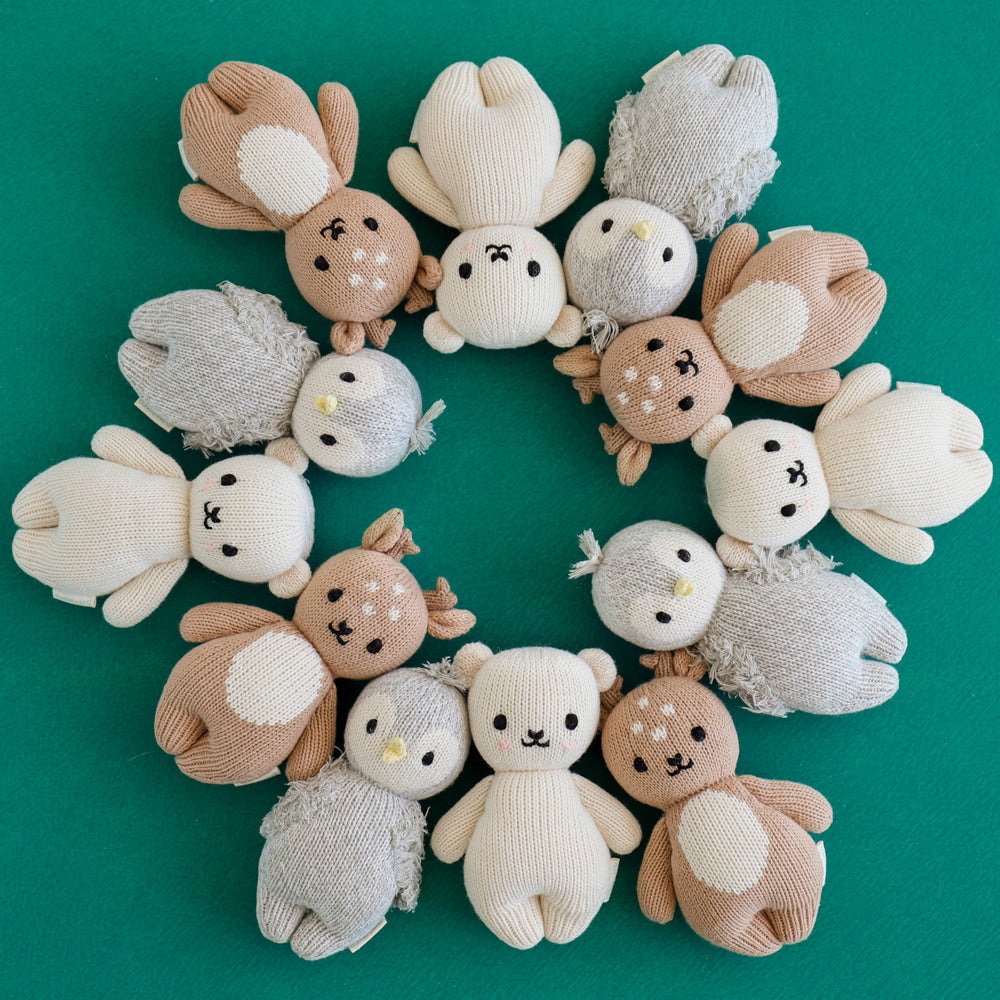 Eight baby animal stuffed dolls lying head-to-head in a circle.