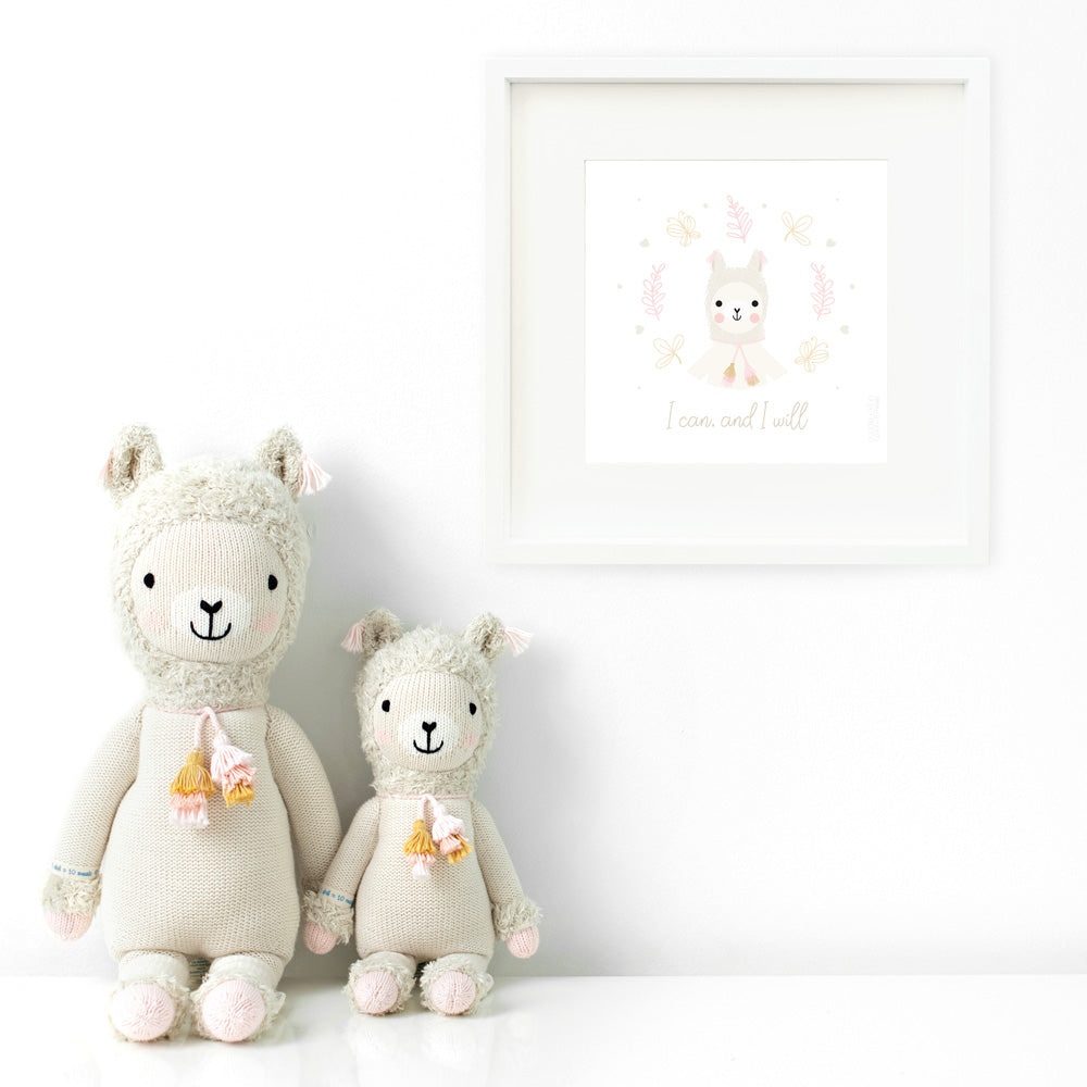 Two Lola the llama stuffed animals sitting beside a framed print with a picture of Lola that says “I can, and I will.”